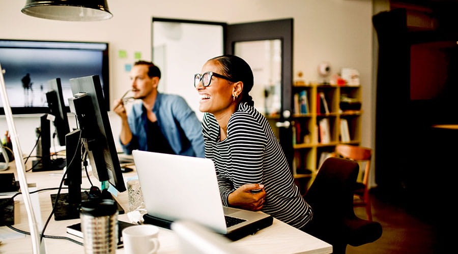  Professionals working together at computer in office