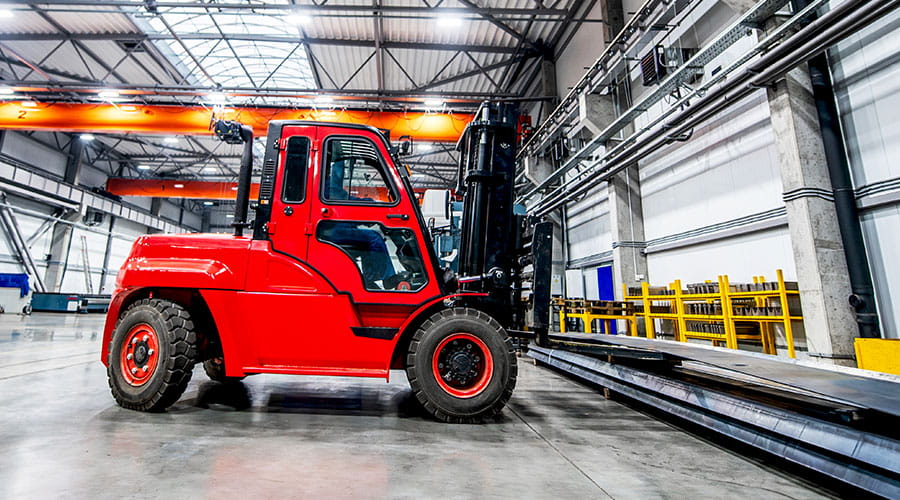  Red forklift operating inside warehouse environment