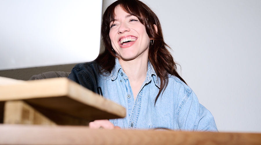  Woman smiling while looking at computer monitor