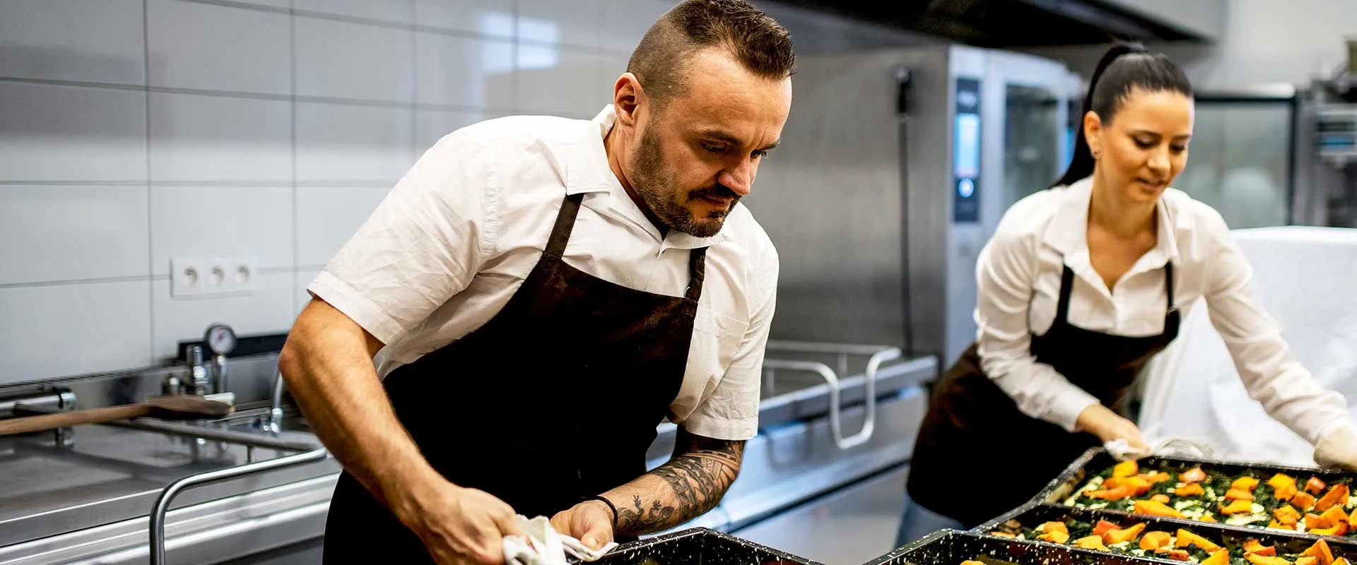 Chef che preparano il cibo insieme in una cucina professionale.