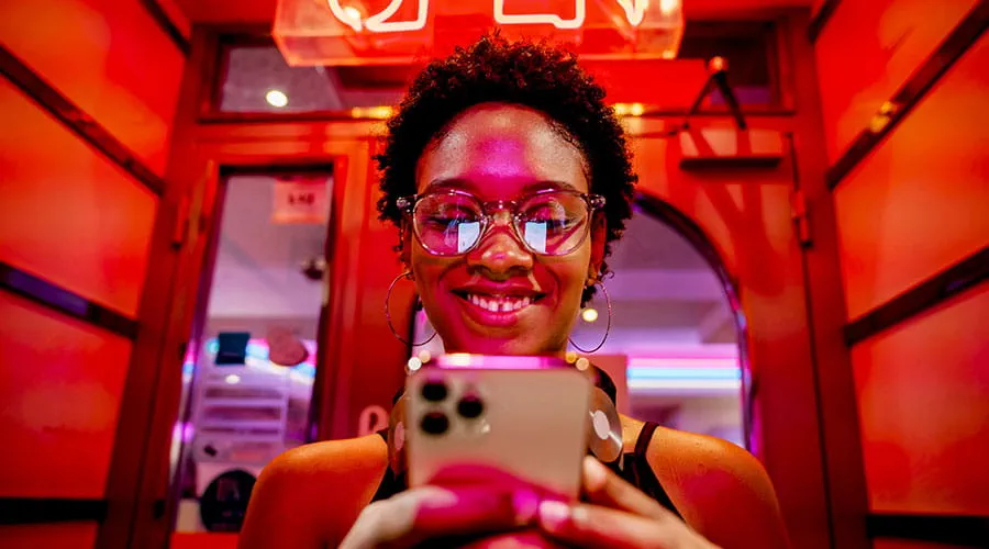 Persona che usa lo smartphone sotto una luce rossa